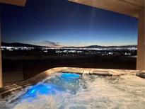 Relax in a hot tub with stunning city views at night at 1056 Calico Ridge Dr, Henderson, NV 89011