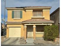 Two story house with tan exterior, green shutters, and a two car garage at 6824 Mesita Ave, Las Vegas, NV 89122