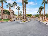 Gated community entrance with palm trees and paved road at 2110 Los Feliz St # 1066, Las Vegas, NV 89156