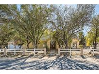 Single-story home with a white fence and mature trees in the front yard at 6325 Guy Ave, Las Vegas, NV 89131