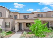 Two-story light brown and gray townhouse with gray door at 10772 Briset Ct, Las Vegas, NV 89166