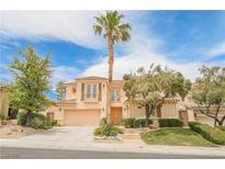 Two-story home with a palm tree, lush landscaping and a large driveway at 11534 Glowing Sunset Ln, Las Vegas, NV 89135