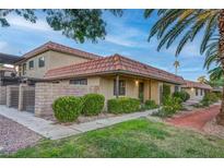 Tan stucco condo building with a red tile roof, and well-manicured landscaping at 744 Apple Tree Ct, Henderson, NV 89014