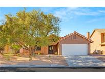 House exterior showcasing a large tree and a driveway at 7975 Aspendale Dr, Las Vegas, NV 89123