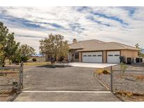 Single-story home with three-car garage and fenced yard at 891 Indole St, Pahrump, NV 89048