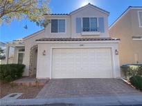 Two-story house with attached garage and landscaped yard at 6269 Glimmering Light Ave, Las Vegas, NV 89139