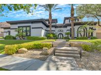 Stunning two-story home with a modern design, landscaped front yard, and palm trees at 1529 Villa Rica Dr, Henderson, NV 89052