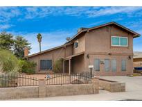 Two-story house exterior, showcasing a light brown facade and a well-maintained front yard at 3933 Manford Cir, Las Vegas, NV 89104