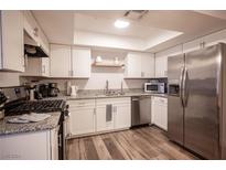 Modern kitchen with stainless steel appliances and granite countertops at 5576 W Rochelle Ave # 30A, Las Vegas, NV 89103