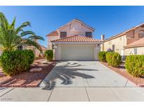 Two-story house with a beige exterior, two car garage, and landscaped yard at 2751 Desert Stream Ct, Las Vegas, NV 89156