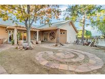 Landscaped backyard with a pergola, stone pathway, and firepit at 1551 Latigo Dr, Henderson, NV 89002