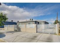Updated home with gray exterior, white fence, and gated entry at 310 Jackson Ave, Las Vegas, NV 89106