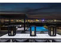 Luxury backyard oasis with a sparkling pool, city views, and a pergola at 617 Overlook Rim Dr, Henderson, NV 89012