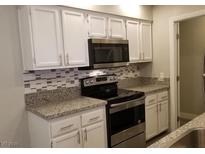 Modern kitchen features granite countertops, stainless steel appliances, and white cabinets at 3608 Melonies Dr # 97, Las Vegas, NV 89103