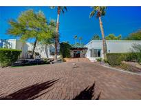 Stunning desert landscaping surrounds this single-story home with a large driveway at 8480 W Ann Rd, Las Vegas, NV 89149