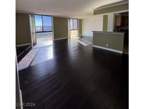 Bright living room with dark hardwood floors and large windows at 3930 University Center Dr # 702, Las Vegas, NV 89119