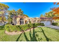 Spanish style home with tile roof, attached garage, and landscaped yard at 5035 Shoal Creek Cir, Las Vegas, NV 89113