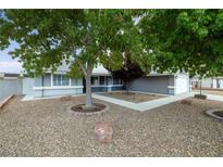 Landscaped front yard with mature trees and a gravel pathway leading to the house entrance at 5200 Wheatland Dr, Pahrump, NV 89061