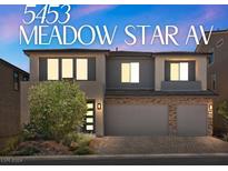 Two-story house with gray siding, stone accents, and a three-car garage at 5453 Meadow Star Ave, Las Vegas, NV 89141