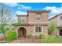 Two-story house with tan siding, arched entryway, and landscaped yard at 8042 Mercury Skye St, Las Vegas, NV 89166