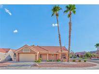 Single-story home with a tan exterior, two palm trees, and a two-car garage at 8913 Stoney Point Dr, Las Vegas, NV 89134