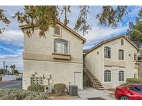 Two-story building exterior with stairs and a red car parked nearby at 1405 S Nellis Blvd # 2027, Las Vegas, NV 89104