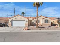 Single-story home with a two-car garage and desert landscaping at 5409 Bible Cir, North Las Vegas, NV 89031