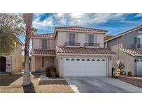 Two-story house with tan exterior, tile roof, and a two-car garage at 5901 Enchanted Palms Ave, Las Vegas, NV 89139