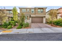 Two-story house with gray siding, a large garage door, and well-manicured landscaping at 909 Riverlawn Pl, Las Vegas, NV 89138