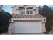 Two-story house with a white garage door and tile roof at 8332 Shore Breeze Dr, Las Vegas, NV 89128