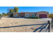 One-story home with stucco exterior, wood-framed pergola, and attached garage at 4890 Willis St, North Las Vegas, NV 89031