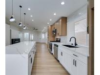 Modern kitchen with white cabinets, quartz countertops, and stainless steel appliances at 7812 Desert Candle Way, Las Vegas, NV 89128