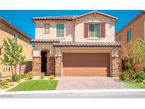 Two-story house with tan exterior, brown garage door, and landscaped front yard at 12540 Mosticone Way, Las Vegas, NV 89141