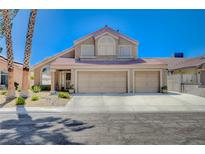 Two-story house with three-car garage, landscaping, and palm trees at 7166 Cloud View Cir, Las Vegas, NV 89119