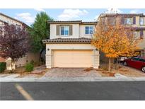 Two-story house with a beige garage door and autumn colored trees in the front yard at 7253 Sterling Rock Ave, Las Vegas, NV 89178