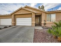 Tan two-story house with a white garage door and landscaped yard at 1197 Simms Ave, Henderson, NV 89074