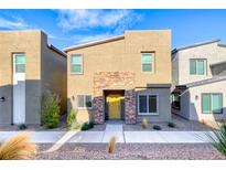 Two-story house with a yellow door and stone accents at 545 Carmel Point Ct, Henderson, NV 89044