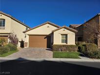 Charming single-story home with a brown garage door, landscaped yard, and paver driveway at 12426 Mosticone Way, Las Vegas, NV 89141