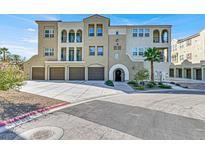 Tan three-story building with multiple garages and a palm tree at 2555 Hampton Rd # 10104, Henderson, NV 89052