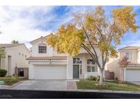 Two-story house with a white garage door and landscaping at 2037 Shining Feather Ln, Las Vegas, NV 89134