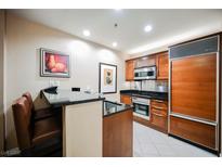 Modern kitchen with stainless steel appliances and wood cabinetry at 145 Harmon Ave # 208, Las Vegas, NV 89109