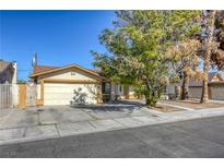 Ranch style home with a two-car garage and mature landscaping at 4880 Welter Ave, Las Vegas, NV 89104