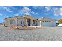 Single-story home with a three-car garage and landscaped front yard at 3580 Prairie Ave, Pahrump, NV 89048