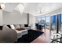 Spacious living room with modern sectional sofa, hardwood floors, and city views at 200 W Sahara Ave # 1804, Las Vegas, NV 89102