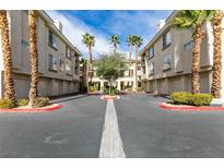 Neatly landscaped apartment building with private garages and palm trees at 7163 S Durango Dr # 302, Las Vegas, NV 89113