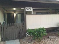 Condo building exterior with a small fenced patio area and landscaping at 3008 Saint George St # C, North Las Vegas, NV 89030