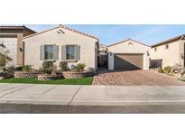 Single-story home with attractive landscaping and a brick driveway at 689 Corelli Cove St, Henderson, NV 89011