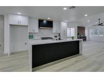 Remodeled kitchen with island, white cabinets, and modern appliances at 7413 Turtle Dove Ct, Las Vegas, NV 89129