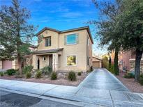 Two-story house with a beige exterior, driveway, and landscaping at 6437 Boatbill St, North Las Vegas, NV 89084