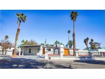 Remodeled mid-century modern home with orange door, gray exterior, and landscaped yard at 3212 Gaucho Dr, Las Vegas, NV 89169